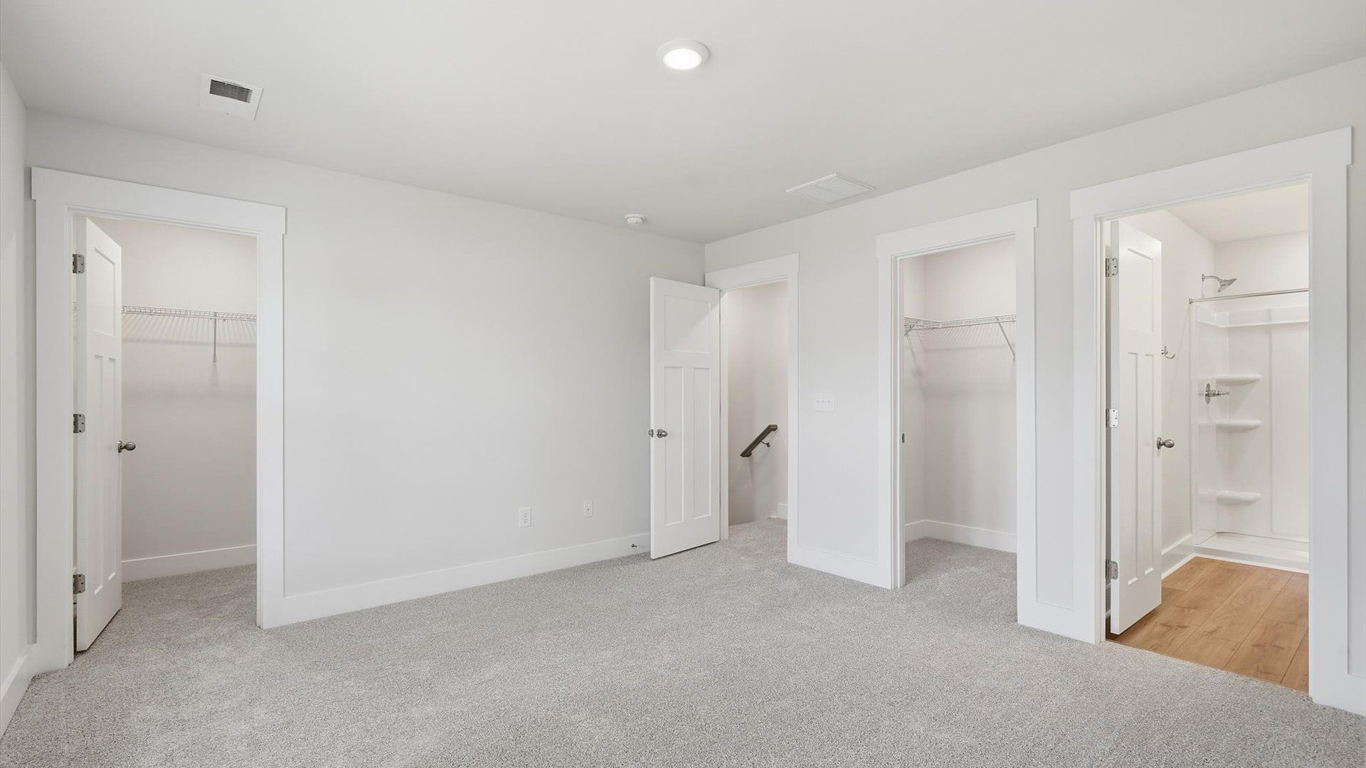 Serene and stylish primary bedroom featuring carpet flooring and a thoughtful, modern layout at Clarke Townes
