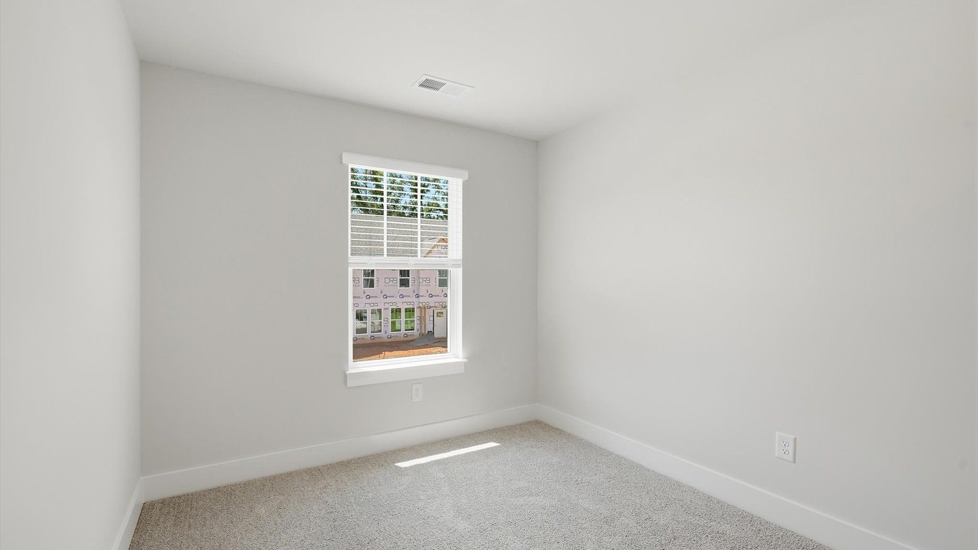 Refined bedroom design with a large window for daylight-filled mornings and peaceful views by DRB Homes