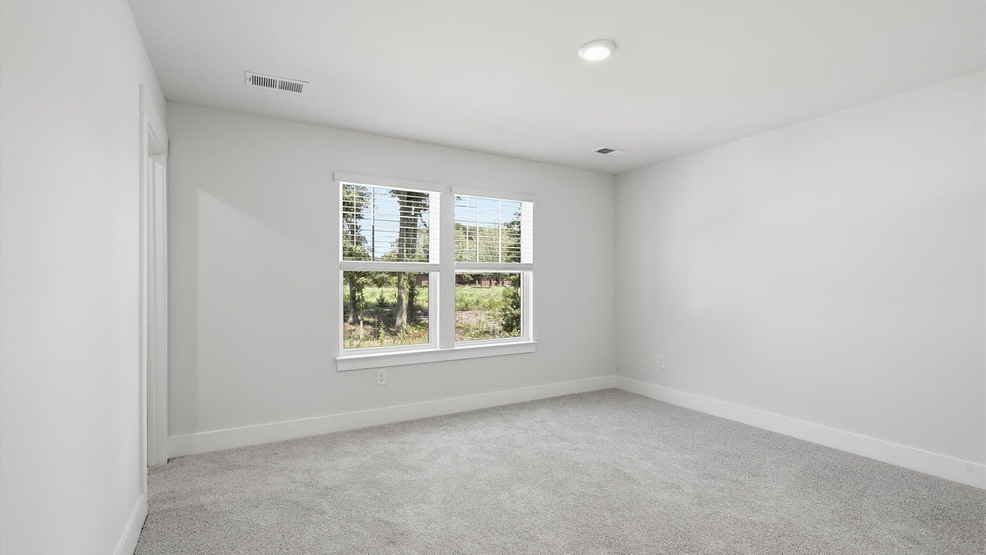 Serene and stylish primary bedroom featuring carpet flooring and a thoughtful, modern layout near Downtown Anderson