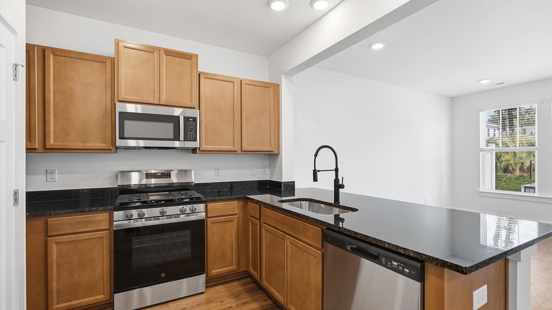 Exclusive kitchen design with granite countertops, stainless appliances, and tasteful finishes throughout at Clarke Townes