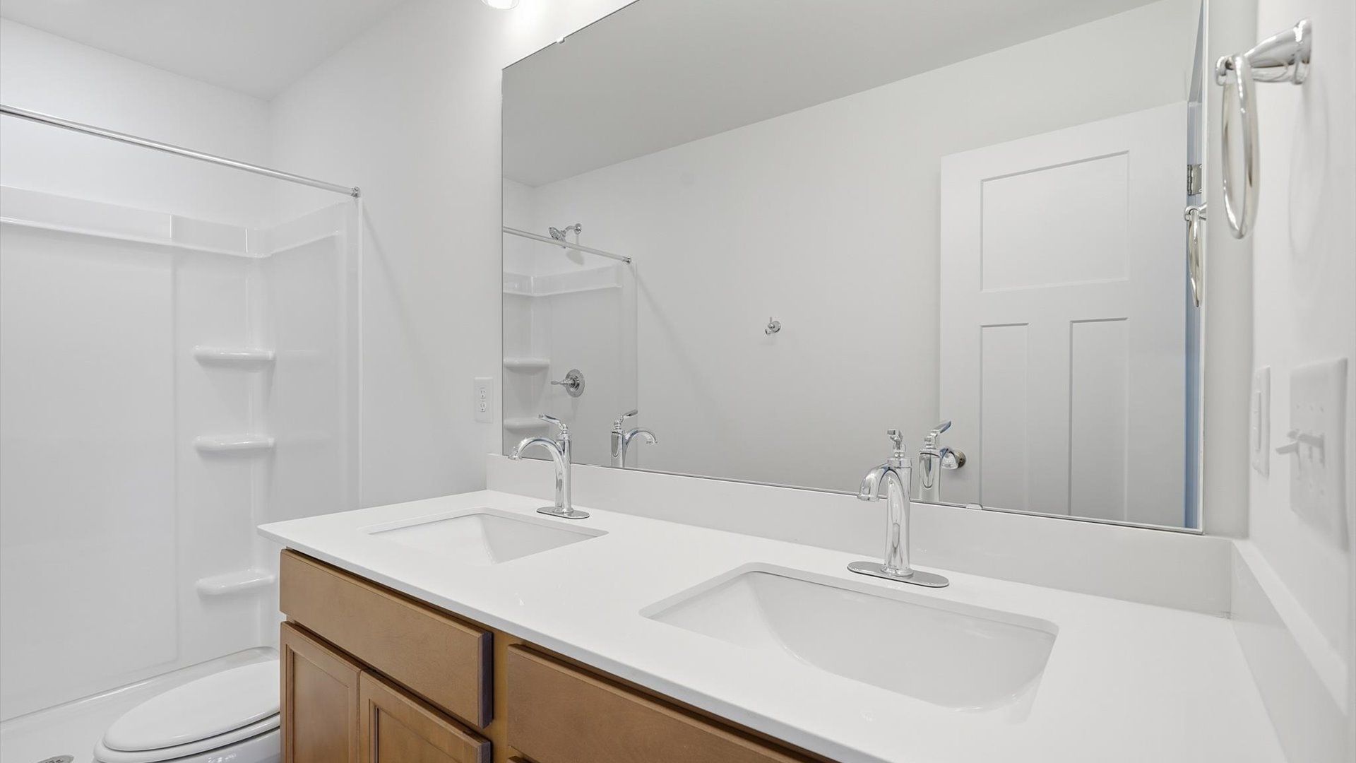 Highly functional and elegant en-suite with dual vanities, tiled walk-in shower, and refined finishes by DRB Homes