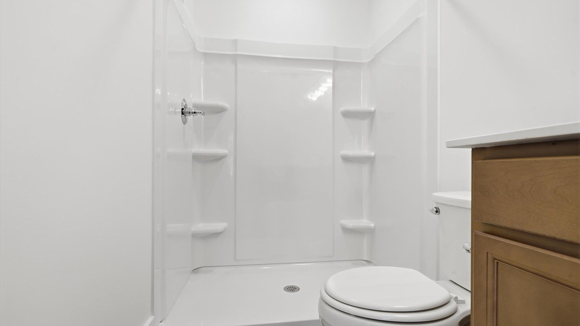 Accomplished design shines in this primary bath with dual vanity and a sleek walk-in shower