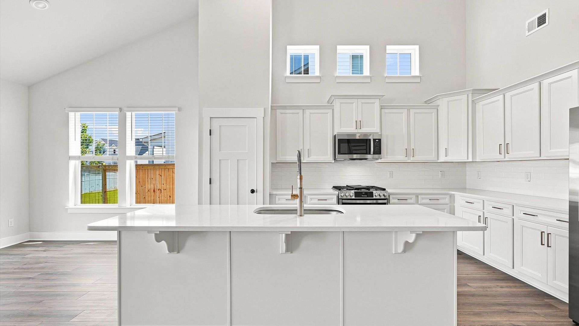 Highly skilled design choices create a clean, open kitchen with a central island