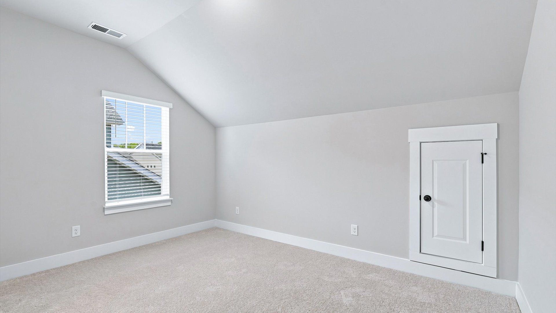 Elegant bedroom retreat featuring soft carpet and oversized windows that create a bright, welcoming space