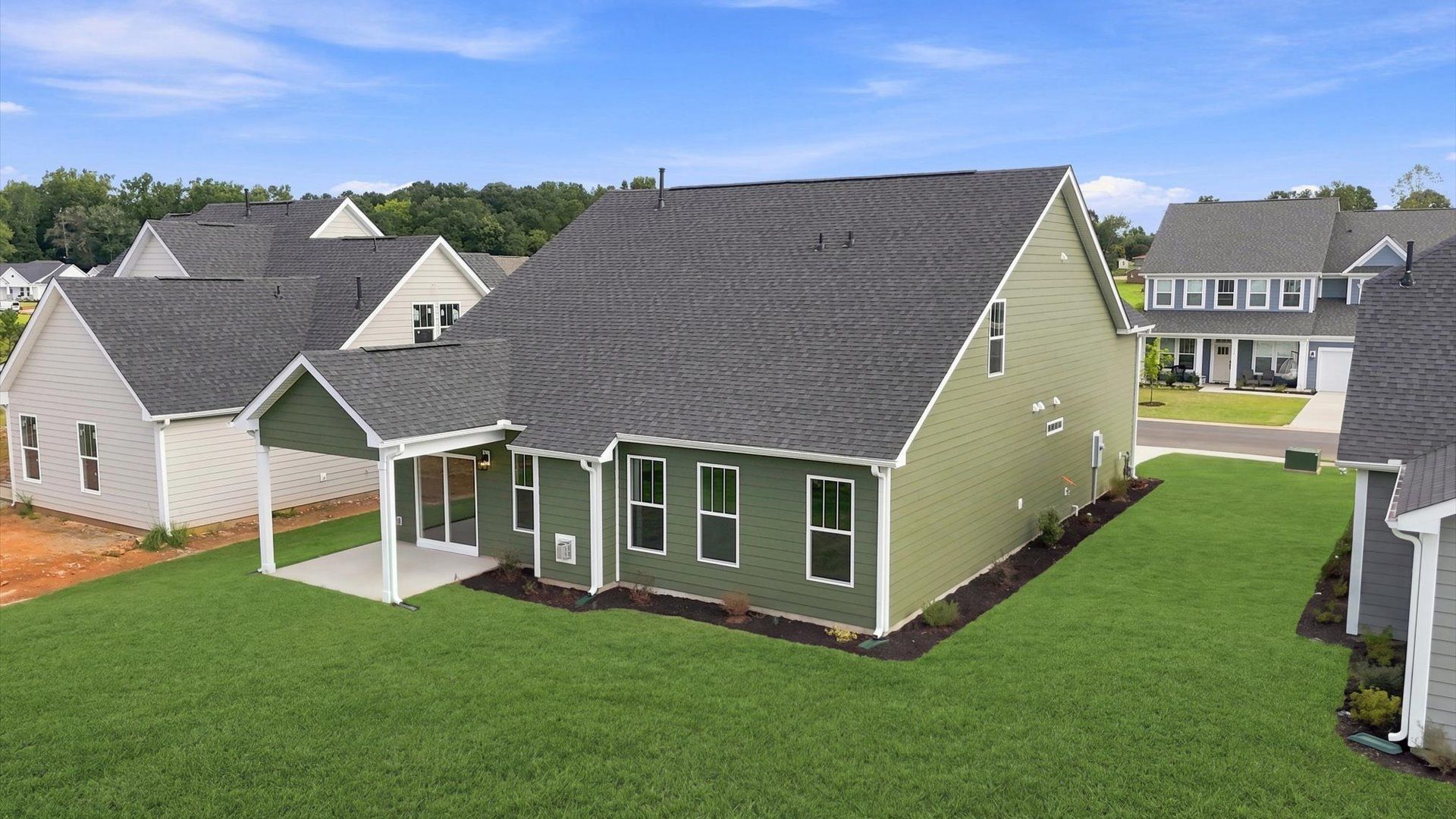 Vibrant rear outdoor space featuring a covered porch and exceptional craftsmanship at Wells Crossing