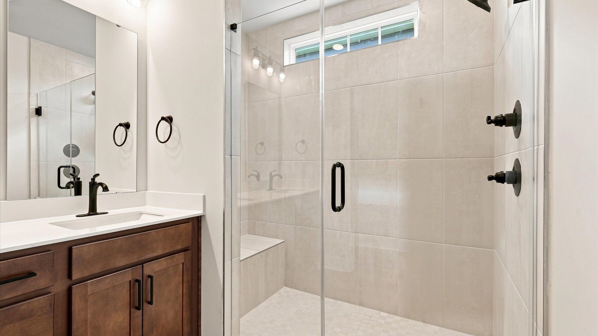 Highly functional and elegant en-suite with dual vanities, tiled walk-in shower, and refined finishes