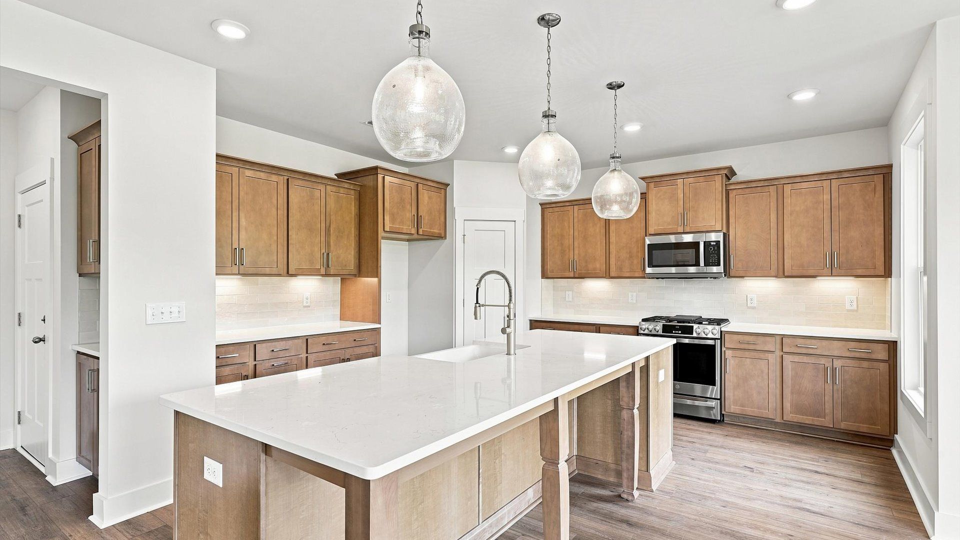 Exclusive DRB Homes kitchen with a 10-foot island, elevated finishes, and pendant lighting in a prime location