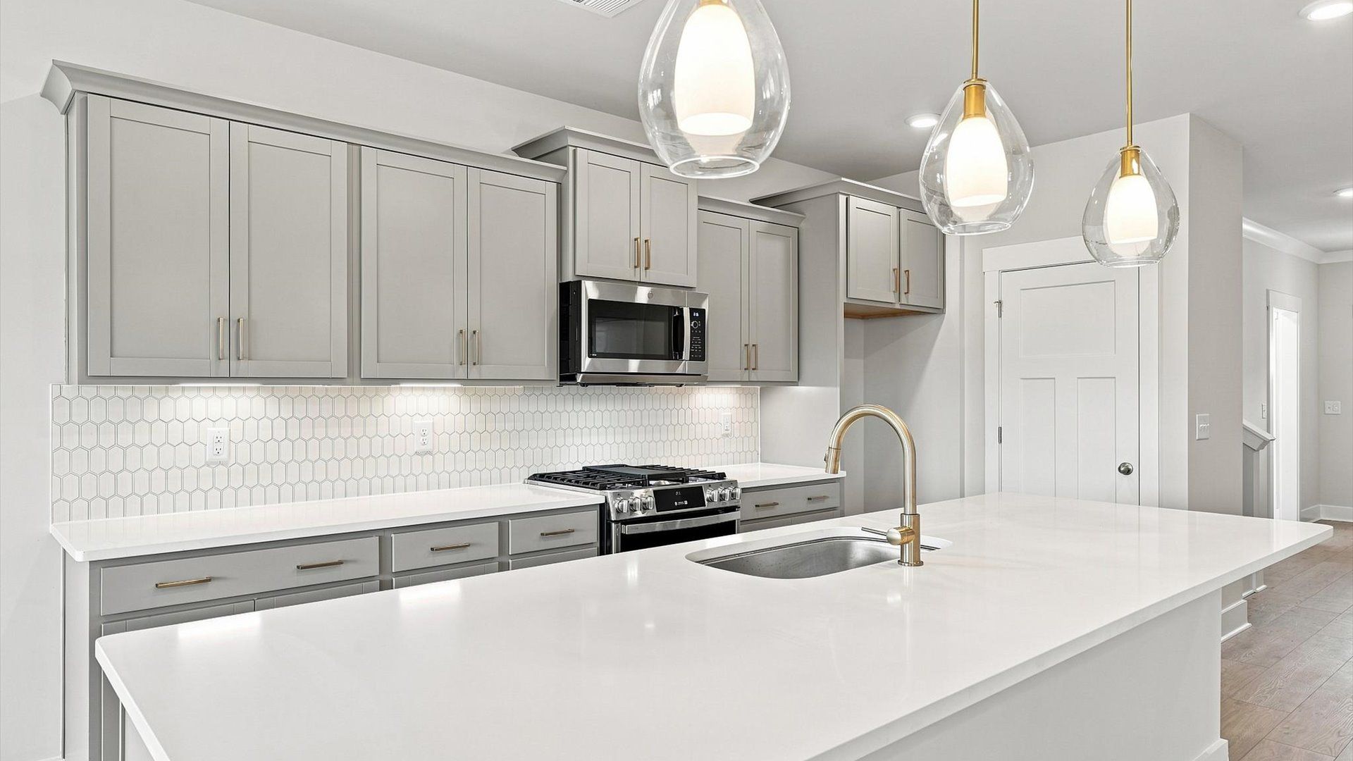 Exclusive DRB Homes kitchen with a 10-foot island, elevated finishes, and pendant lighting in a prime location