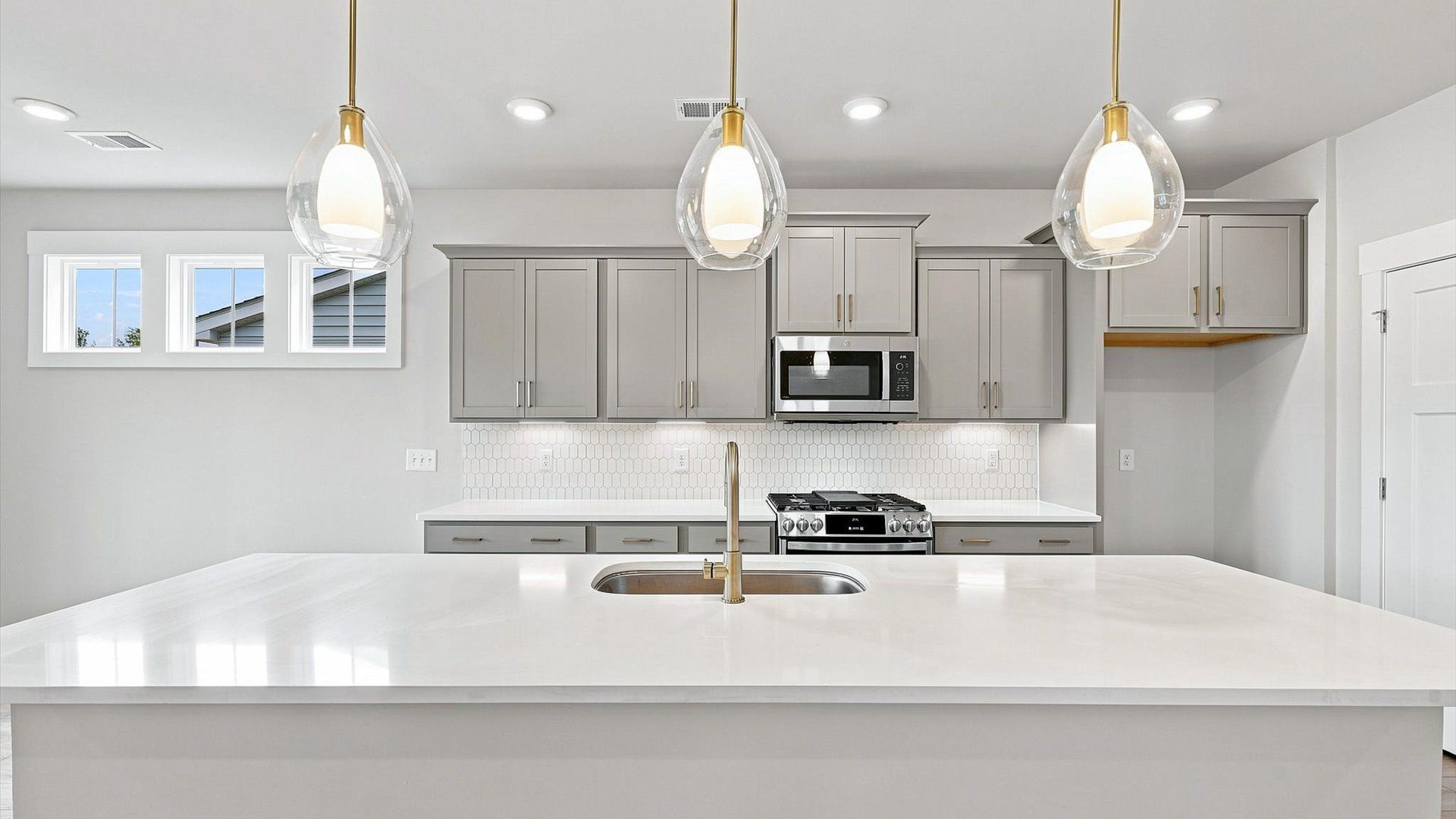 Top-notch kitchen featuring pendant lighting over a statement 10-foot island with seating