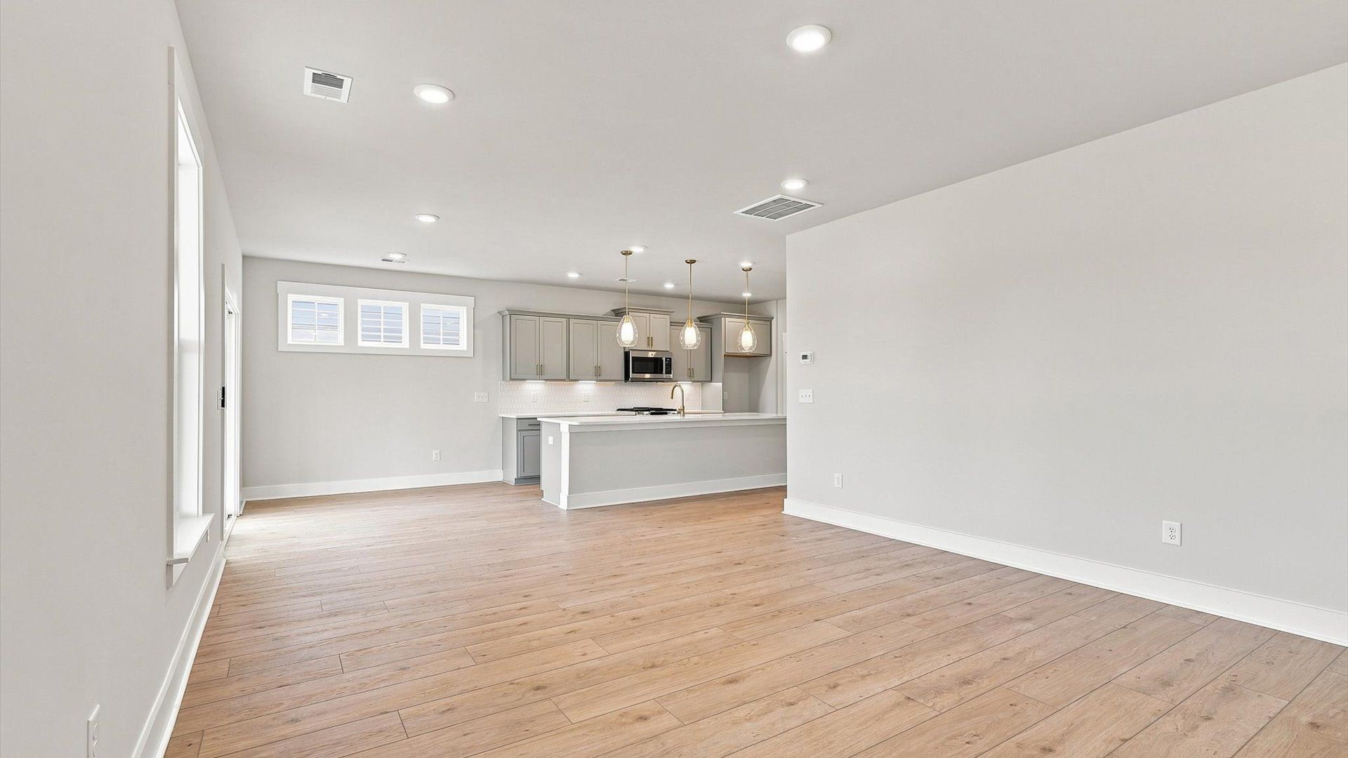 Elegant family room featuring hardwood flooring, large windows, and thoughtful architectural detail