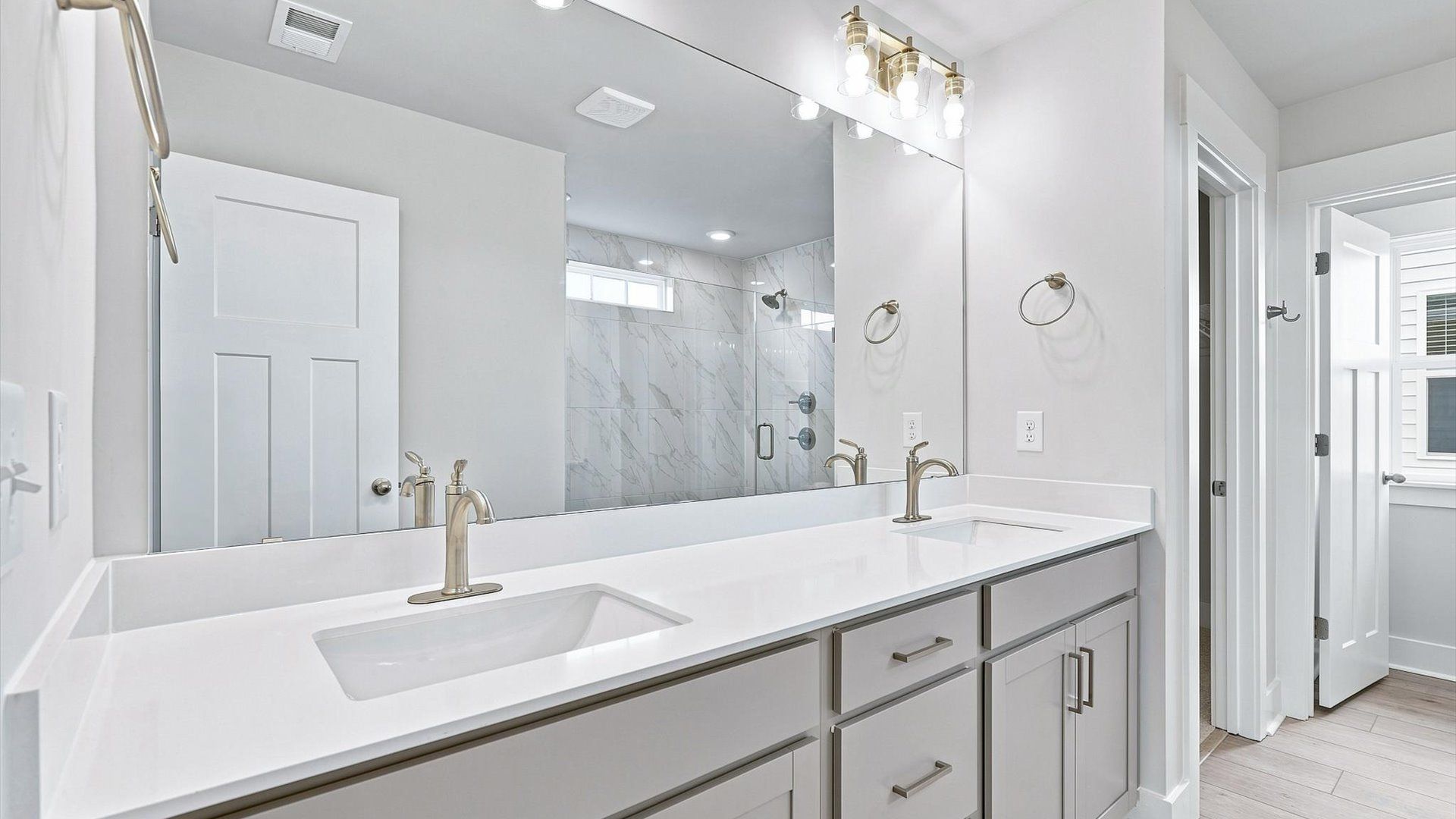 Tasteful primary bath with modern finishes, a tiled walk-in shower, and thoughtful double vanity layout