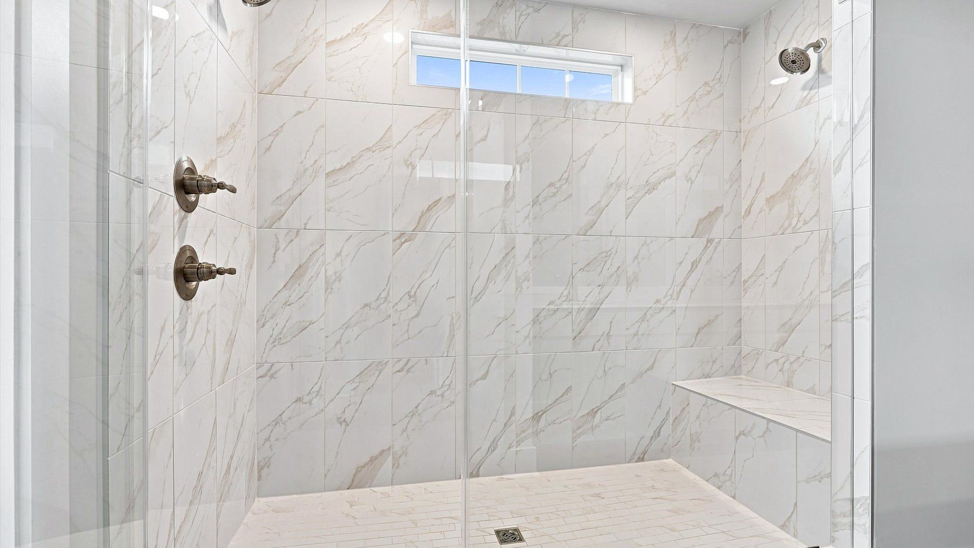 Highly functional and elegant en-suite with dual vanities, tiled walk-in shower, and refined finishes