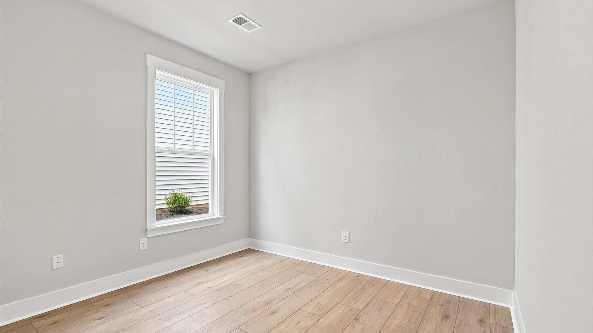Thoughtfully designed secondary bedrooms featuring hardwood flooring and tasteful detail