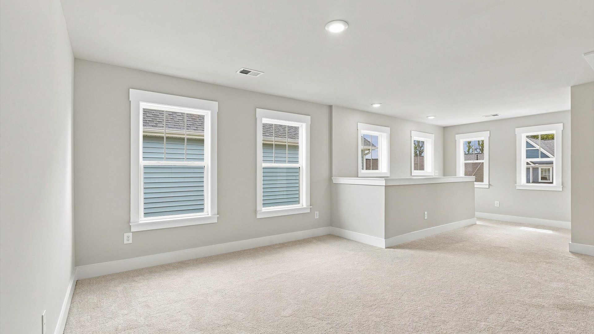 Vibrant carpeted loft offering flexibility as a study nook, game room, or second family space