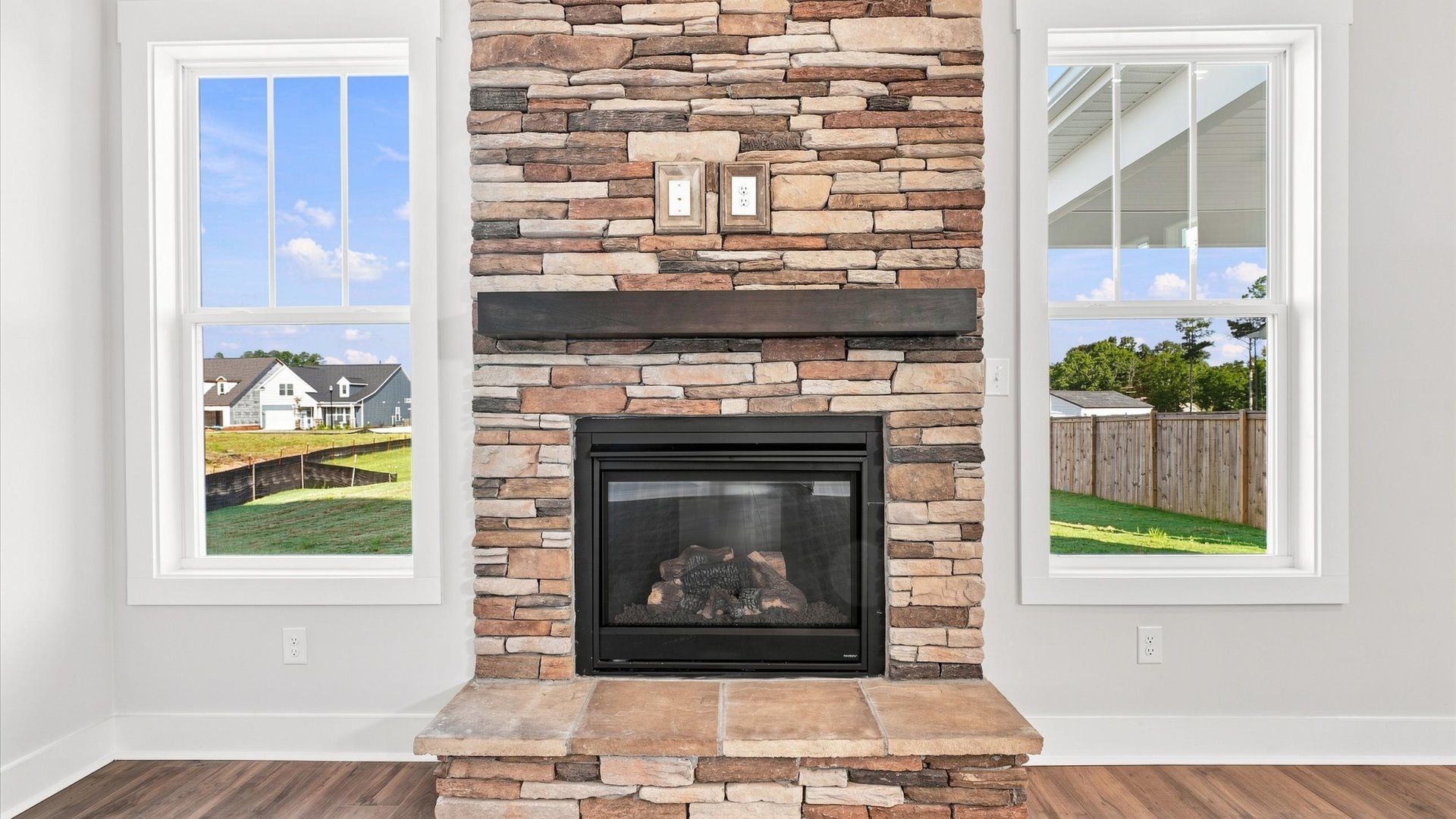 Exceptional family room featuring a stone fireplace and vibrant natural light located near Lake Bowen