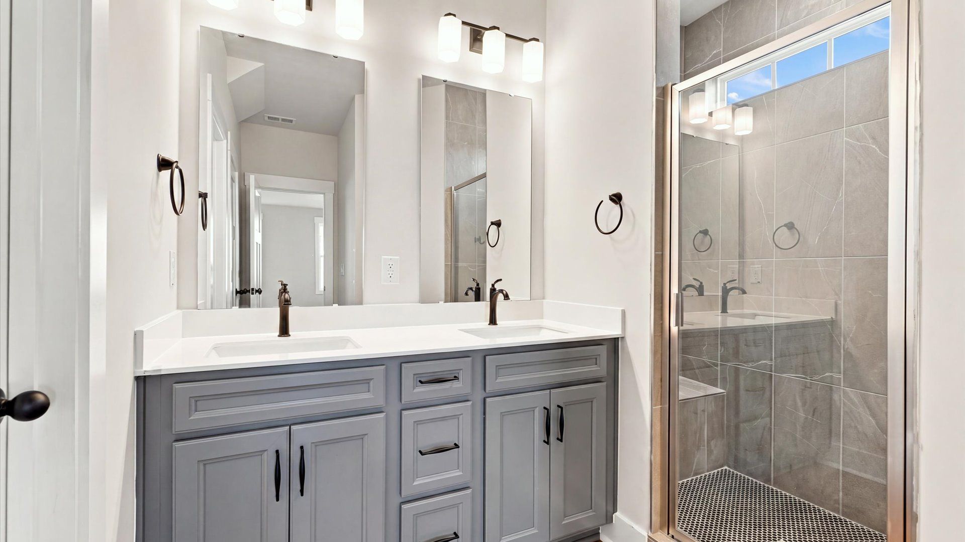 Elegant primary bathroom featuring a spacious walk-in shower and dual vanity in this first-class DRB Homes design