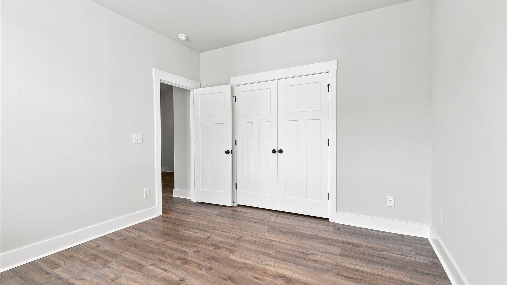 Superior hardwood flooring enhances the comfort and style of this secondary bedroom near Lake Bowen