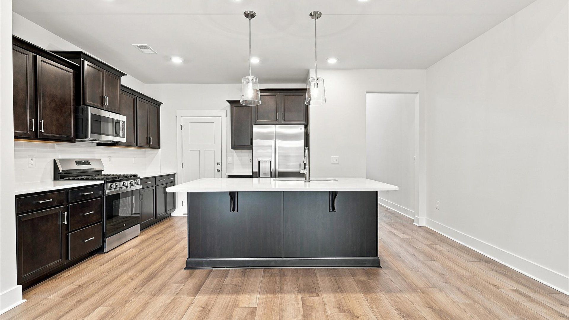 Superior craftsmanship shines in this modern kitchen with a space-saving island and open flow at Village at Midway