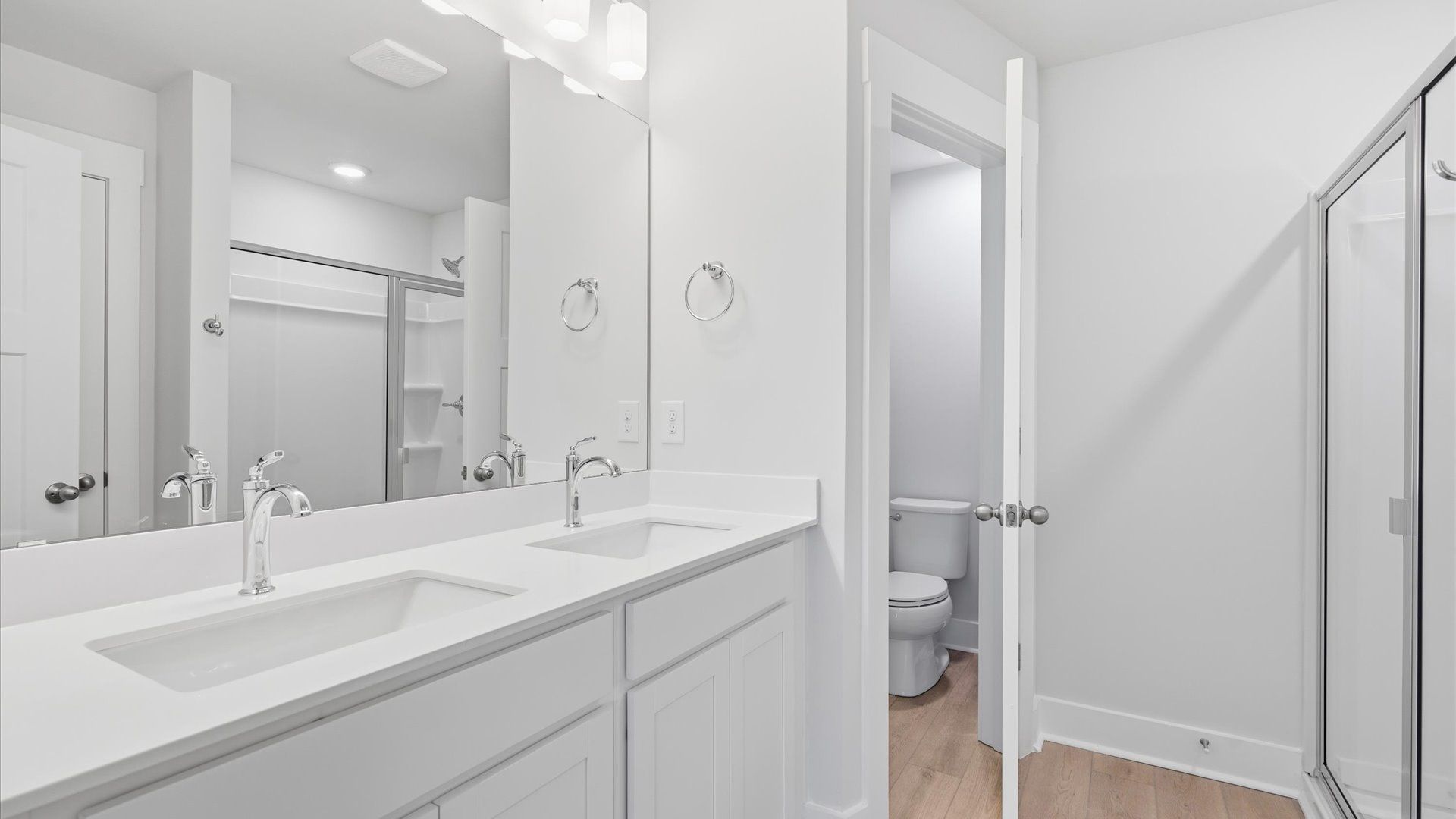 Sophisticated primary bathroom with expansive vanity and polished hardware