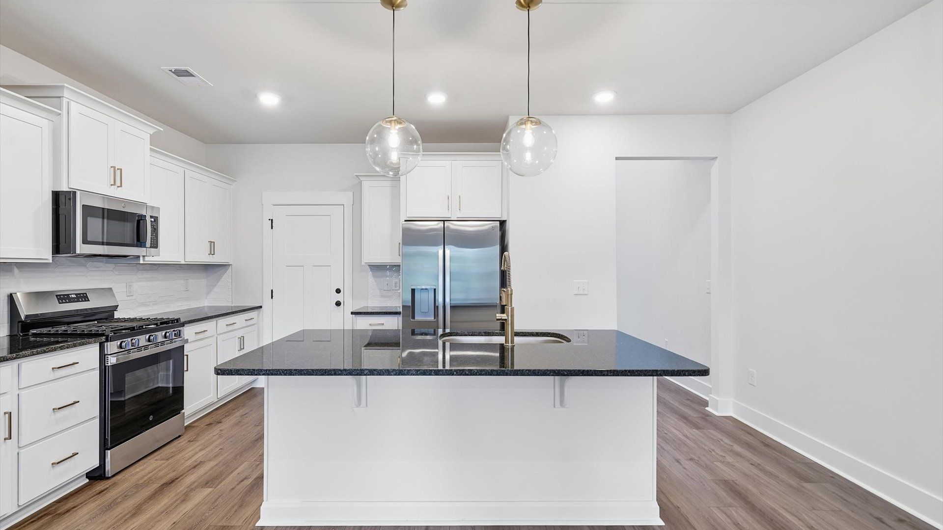 Exceptional kitchen featuring a spacious island, eye-catching pendant lights, and modern finishes near Lake Hartwell