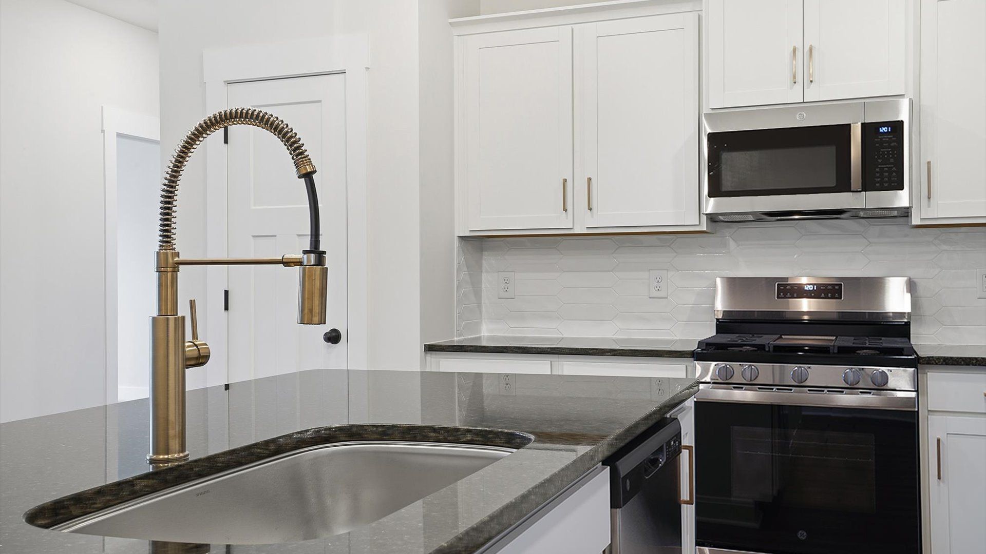 Tasteful kitchen with oversized island and granite countertops—crafted to high standards at Village at Midway