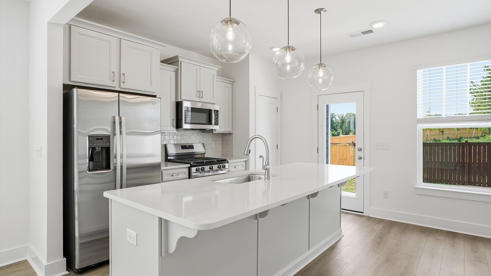 Superior craftsmanship shines in this modern kitchen with a space-saving island and open flow at Barton Hollow