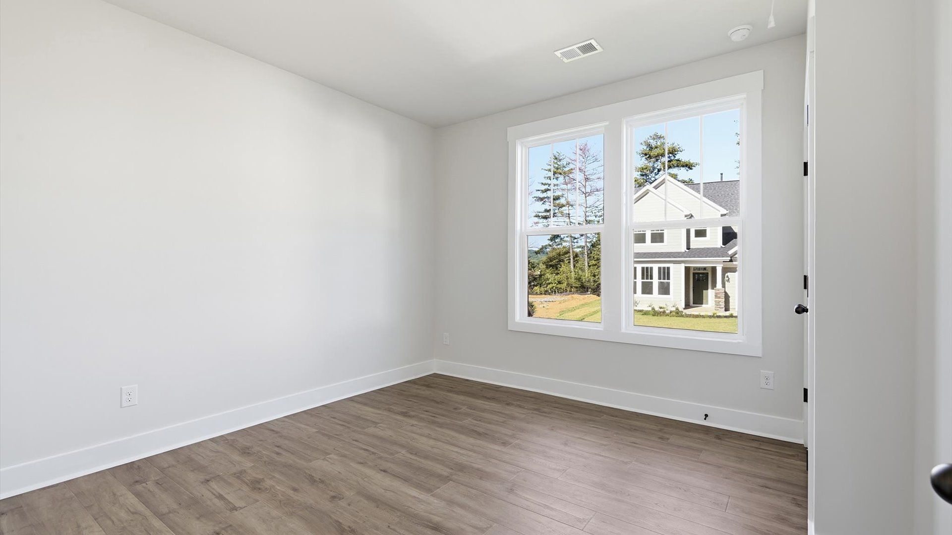 Thoughtfully designed secondary bedrooms featuring hardwood flooring and tasteful detail