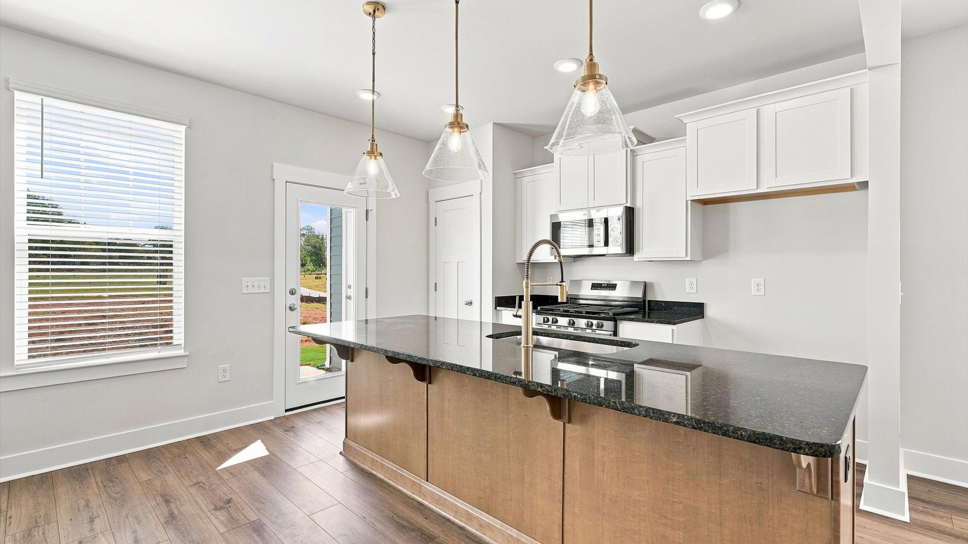 Superior craftsmanship shines in this modern kitchen with a space-saving island and open flow at Saluda Crossing