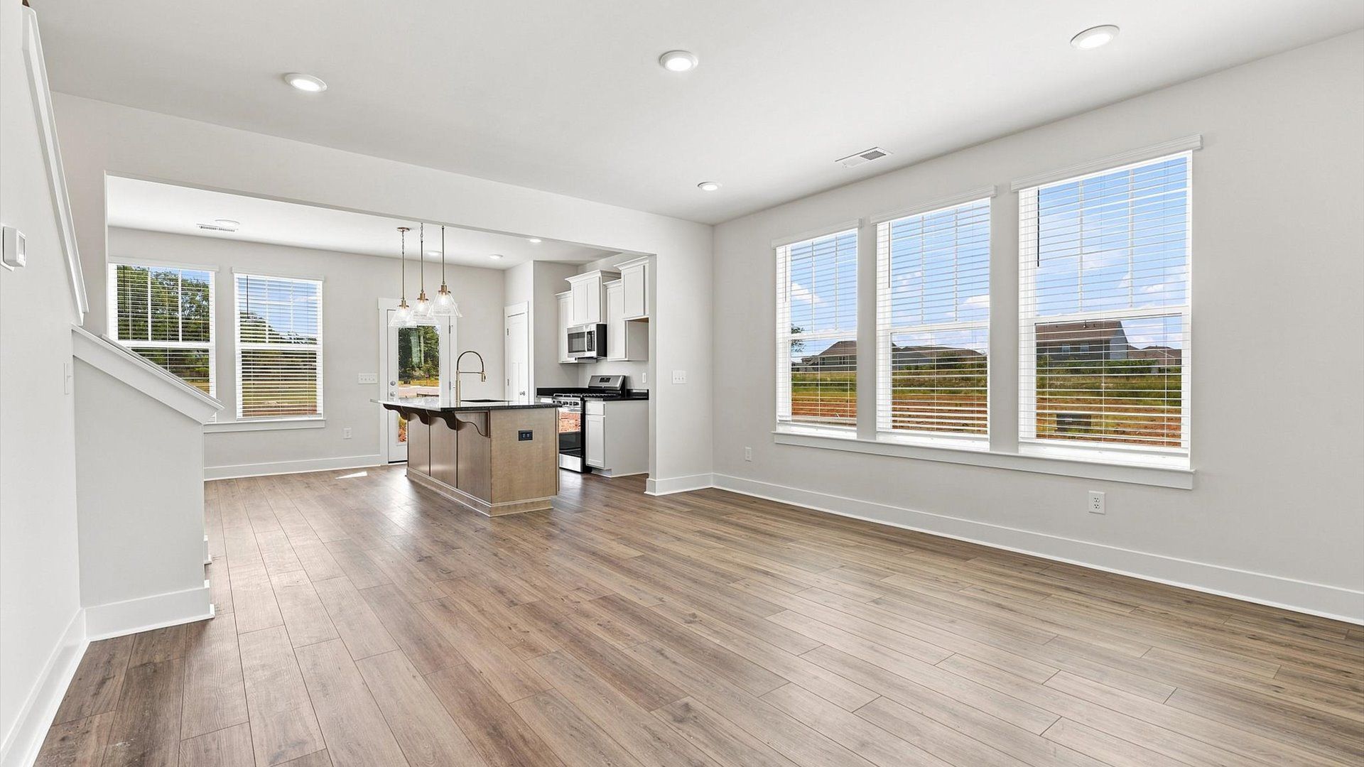 Elegant family room featuring hardwood flooring, large windows, and thoughtful architectural detail