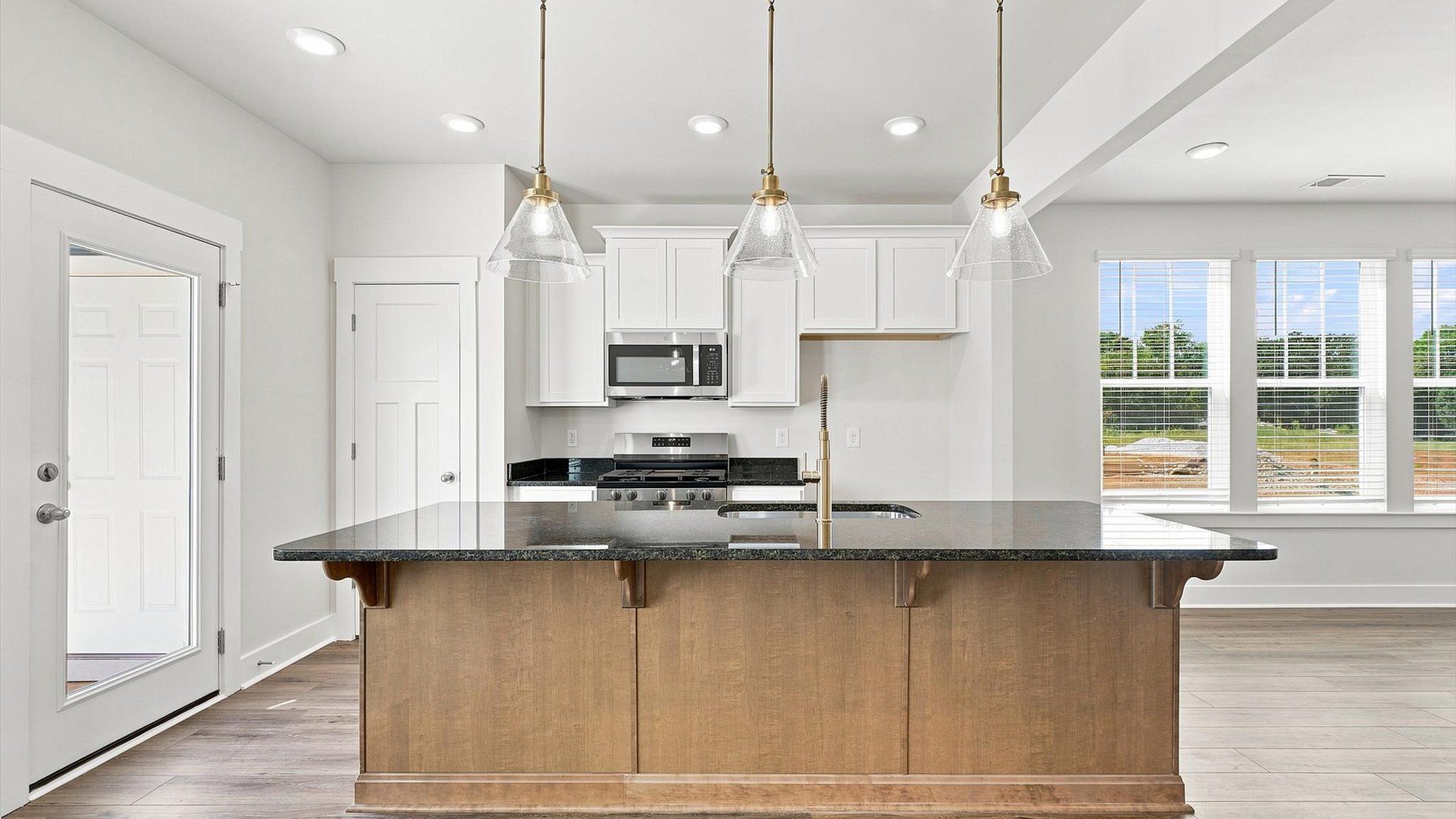 Highly skilled craftsmanship shines in this modern kitchen with pendant lighting and a central island focal point in SC