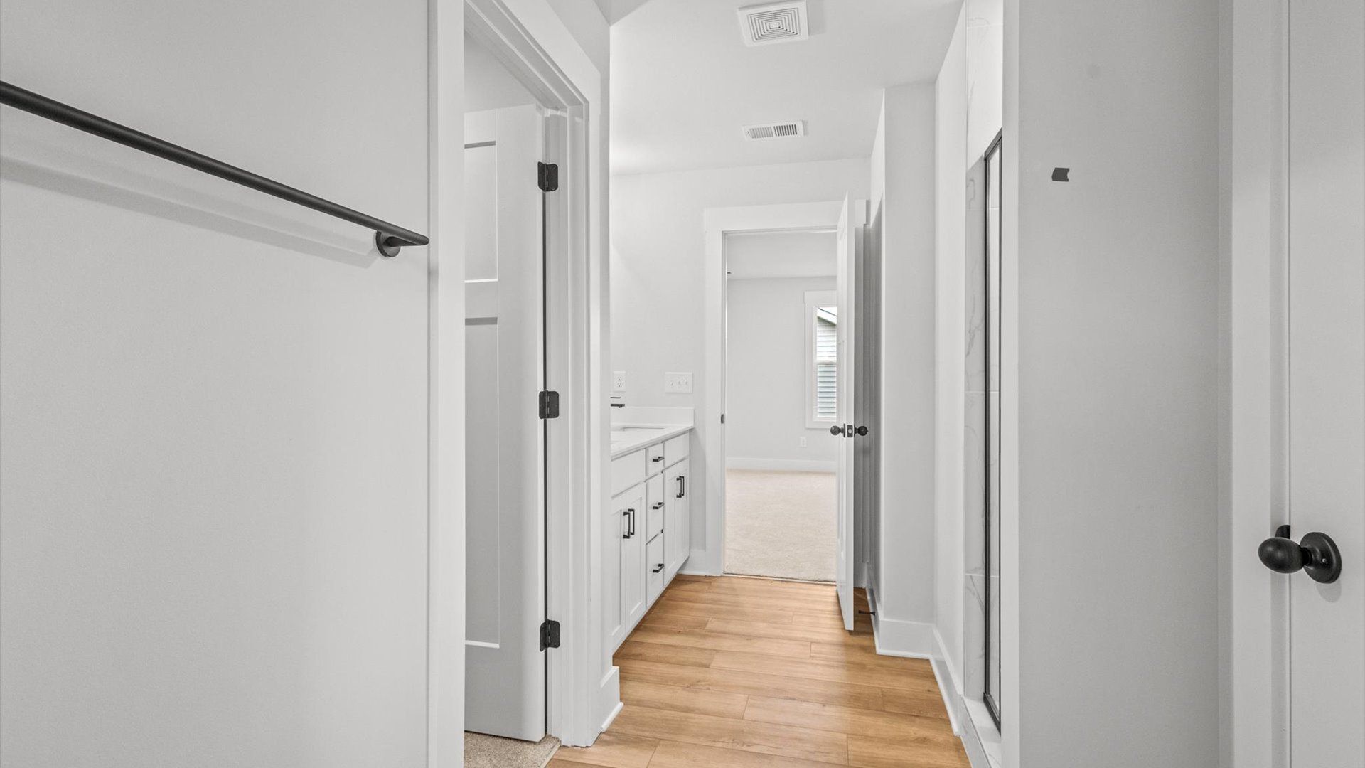 Neroli home plan primary bath with dual vanities, tile shower, toilet room and linen closet