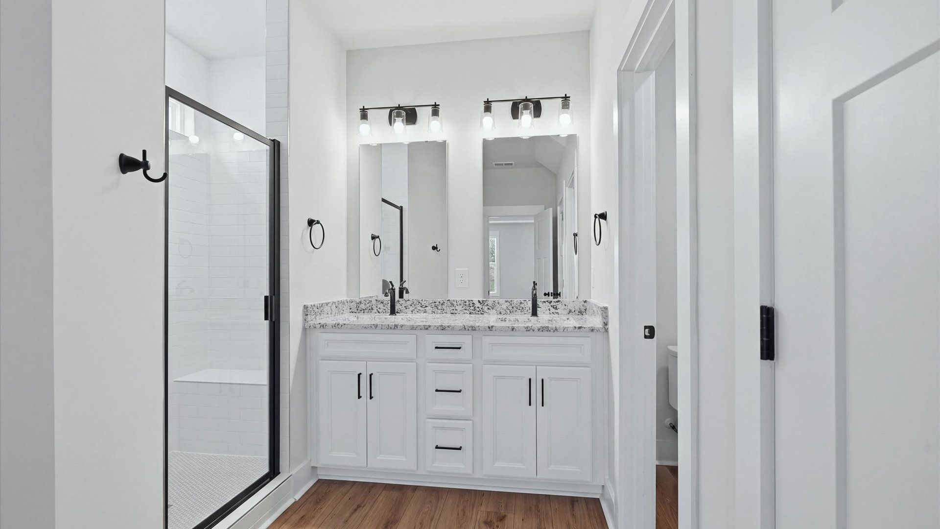 Elegant primary bathroom featuring a spacious walk-in shower and dual vanity in this first-class DRB Homes design