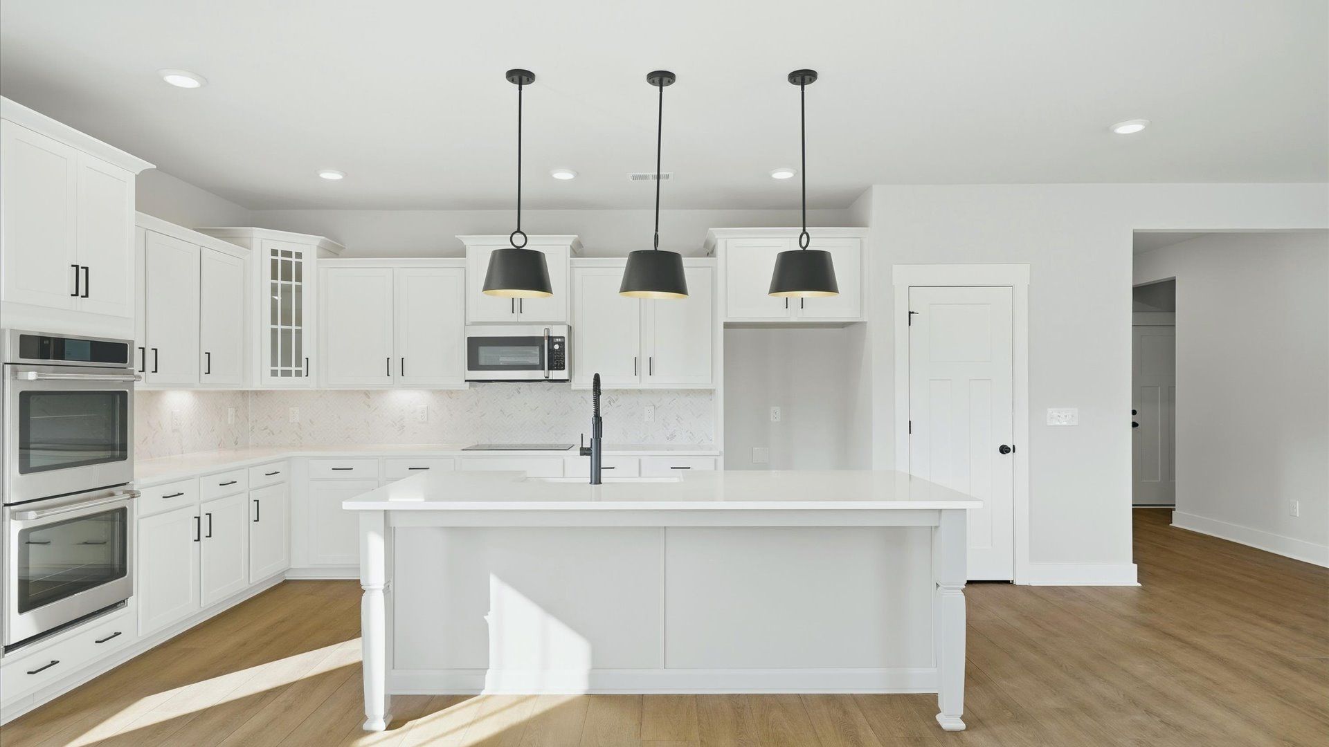 Well-designed kitchen with a center island and tasteful finishes that elevate everyday living by DRB Homes