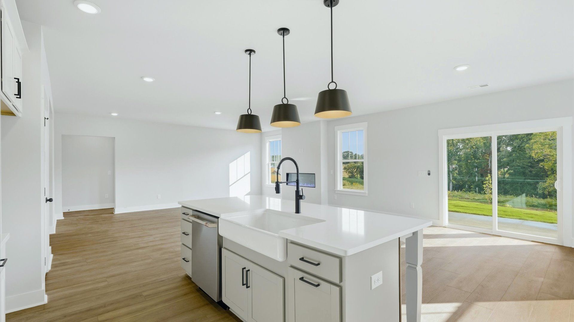 Top-notch kitchen featuring pendant lighting over a statement 9-foot island with seating by DRB Homes