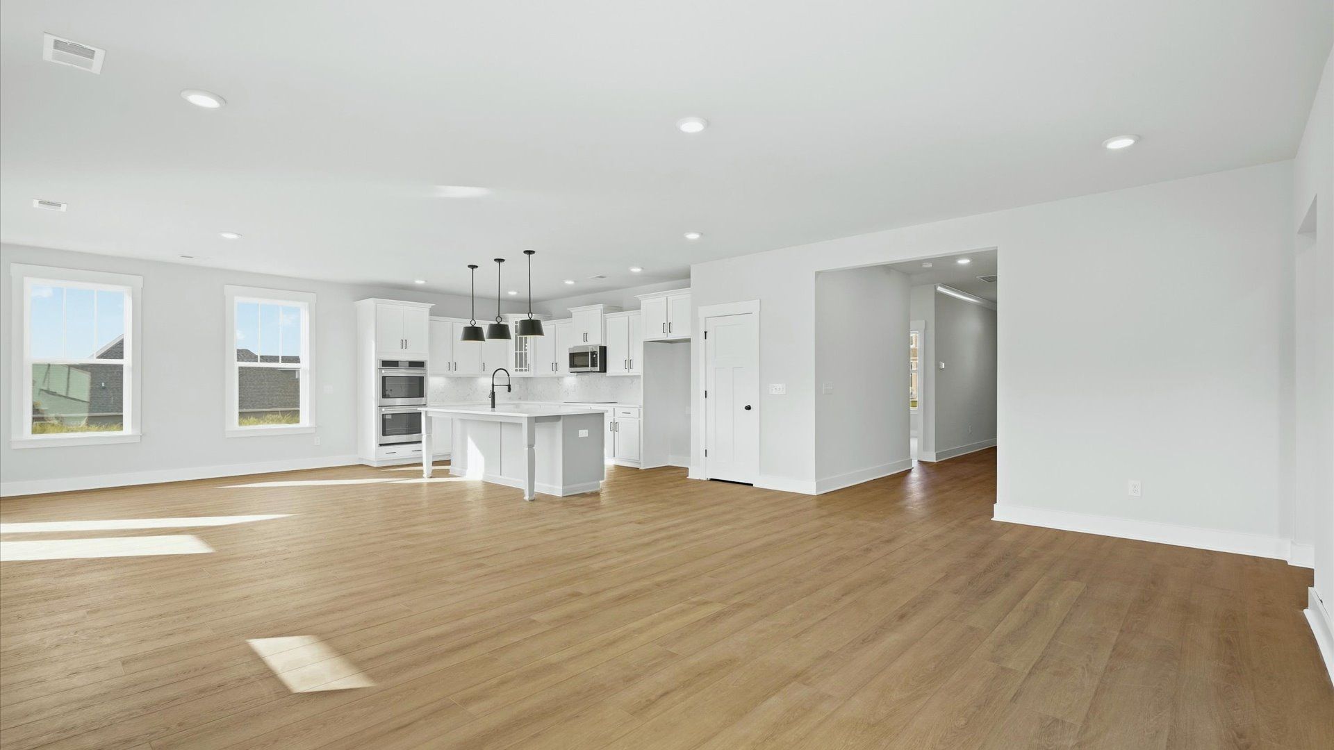 Elegant family room featuring hardwood flooring, large windows, and thoughtful architectural detail