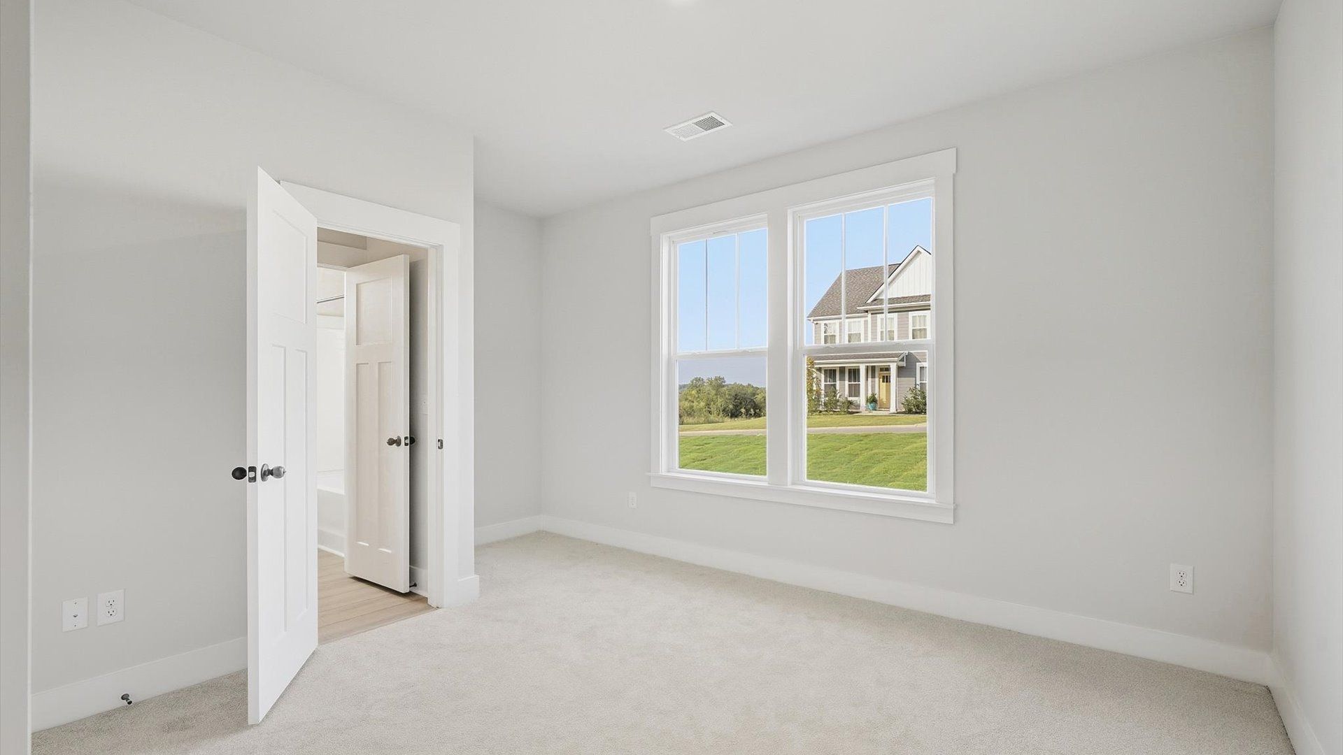Accomplished bedroom layout with cozy carpet, a spacious walk-in closet, and sun-filled windows by DRB Homes