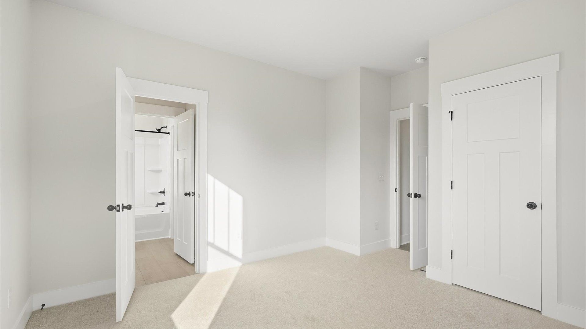 Bright and serene bedroom with comfortable carpeted flooring and large windows for vibrant light by DRB Homes