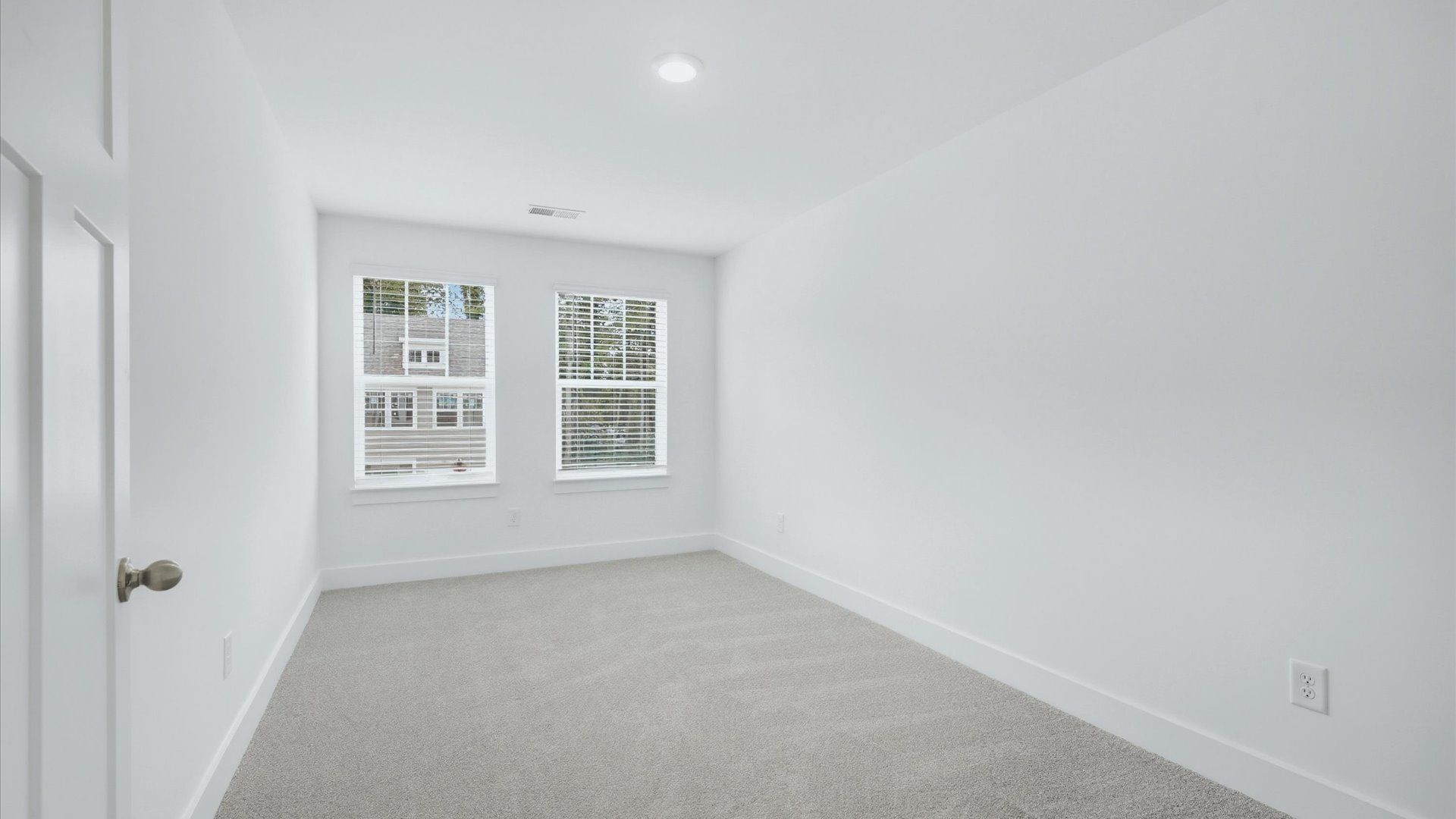 Elegant bedroom retreat featuring soft carpet and oversized windows that create a bright, welcoming space at Brookland Place