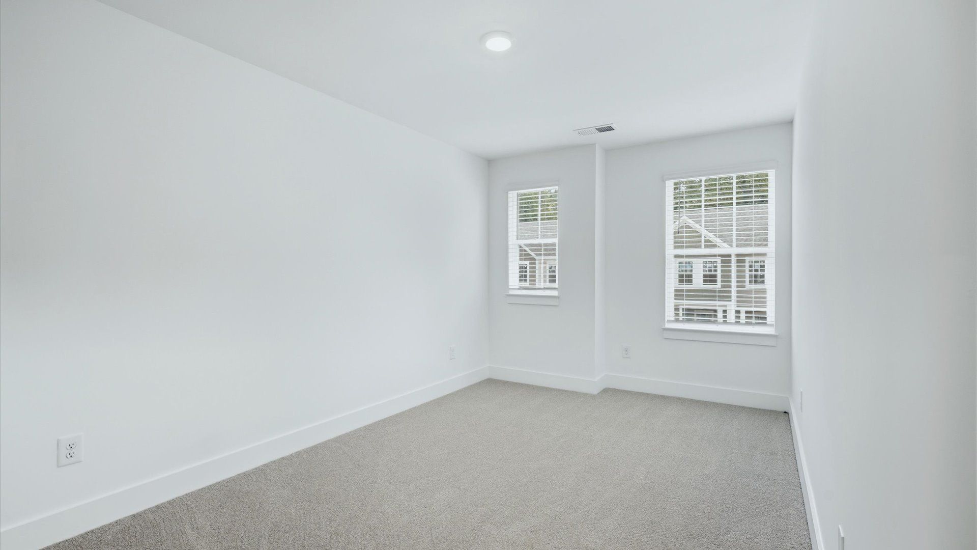 Notable bedroom offering soft carpet, a walk-in closet, and expansive windows overlooking the yard in NC