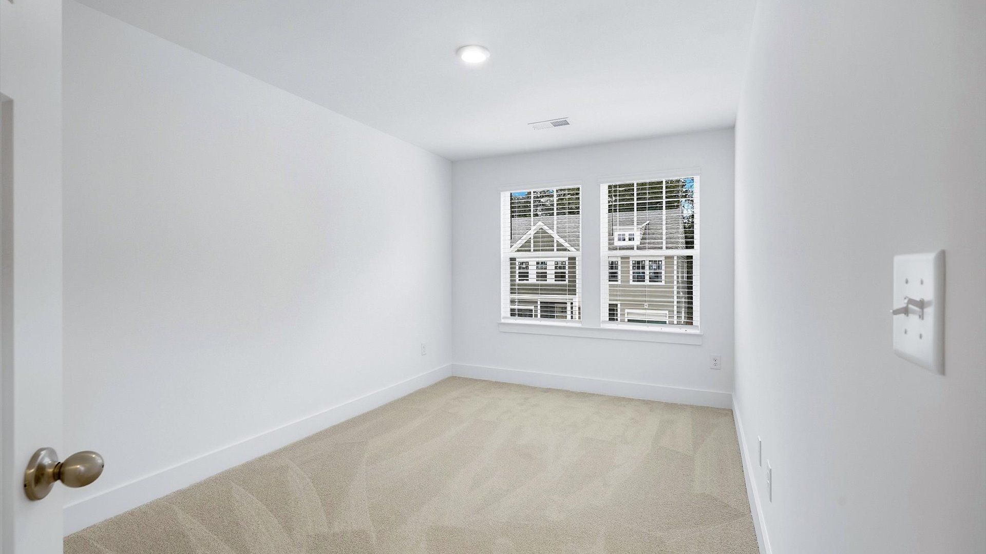 Bright and serene bedroom with comfortable carpeted flooring and large windows for vibrant light at Brookland Place