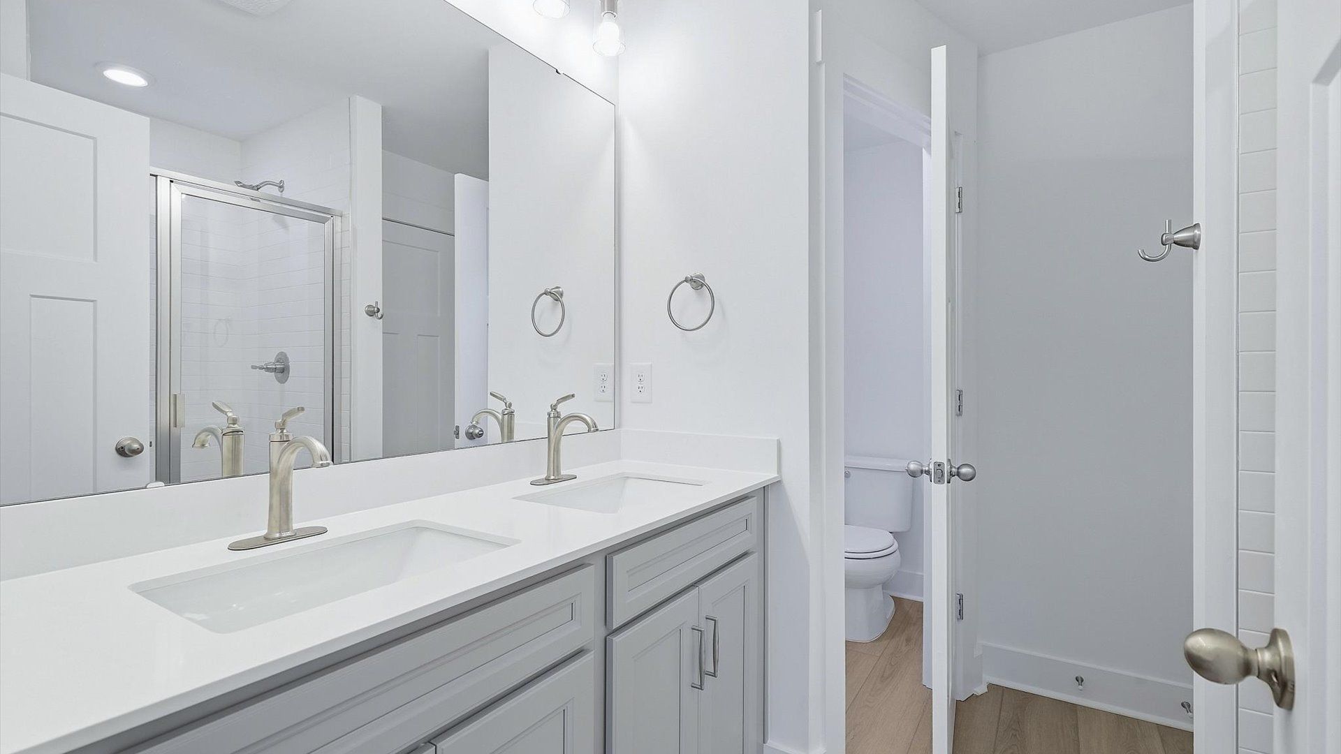 Spacious and modern primary bathroom with walk-in shower and first-class double vanity setup by DRB Homes