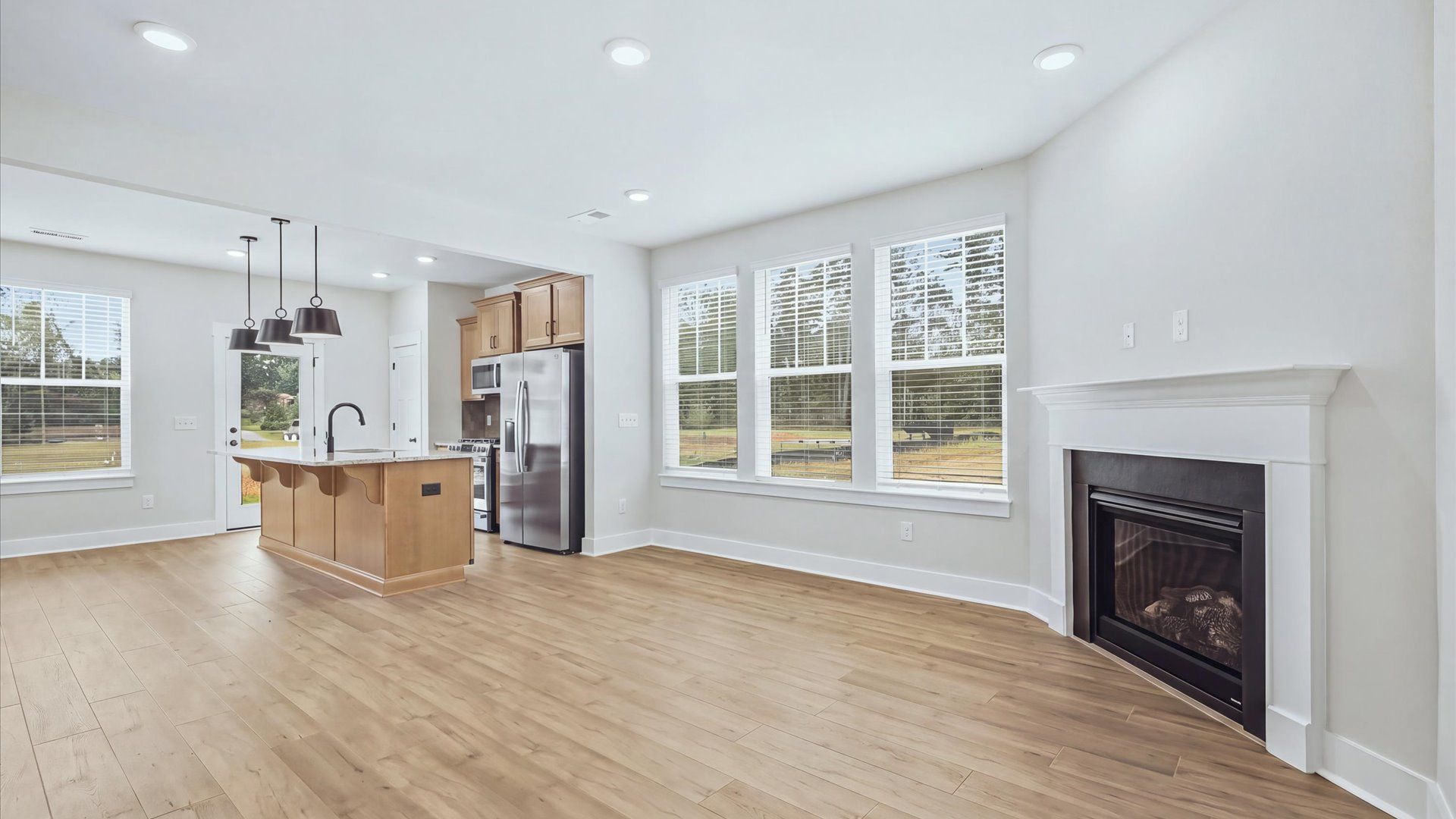 Elegant family room featuring hardwood flooring, large windows, and thoughtful architectural detail by DRB Homes