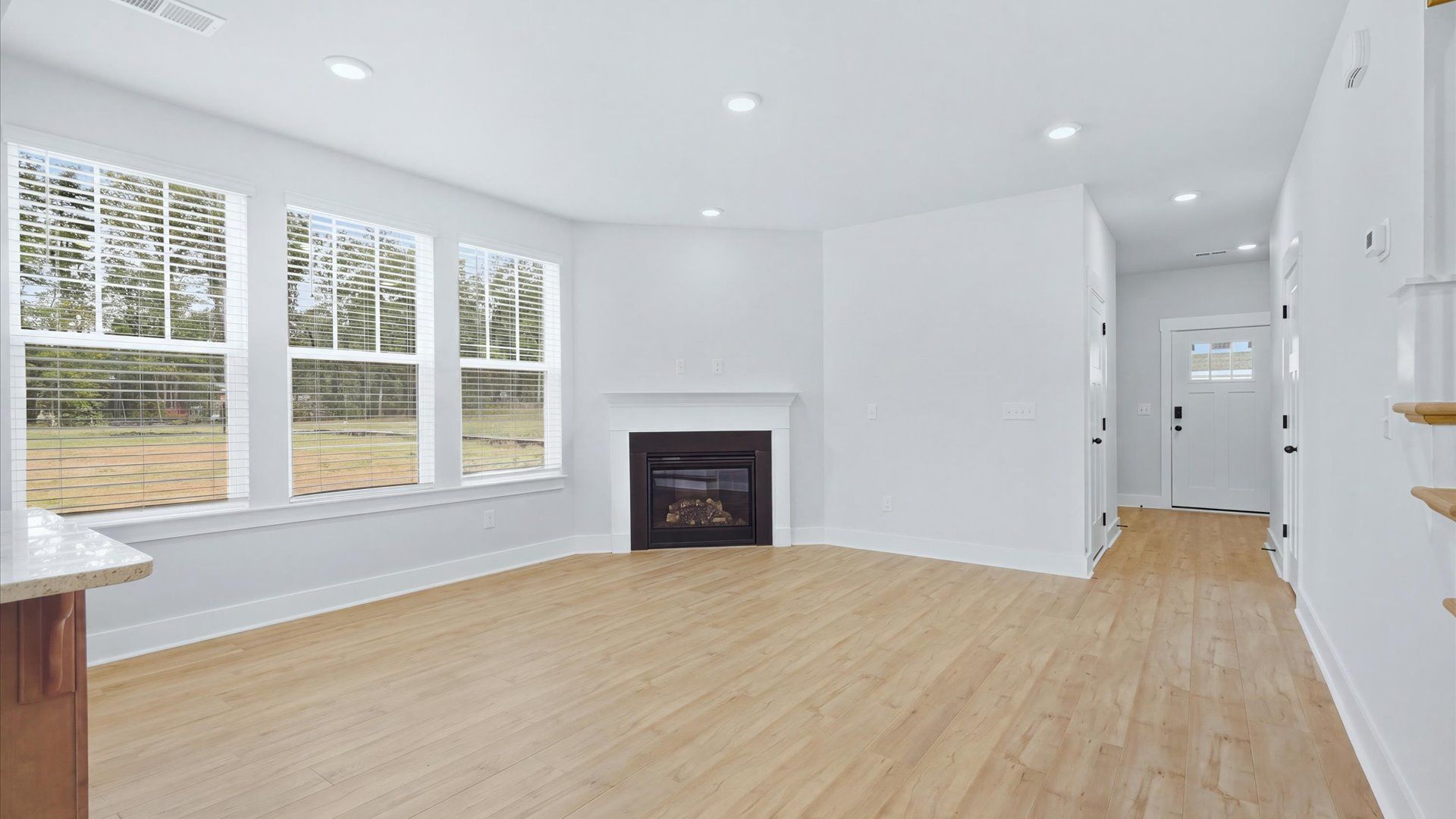 Hardwood flooring and high standards define this vibrant family room ideal for everyday living by DRB Homes