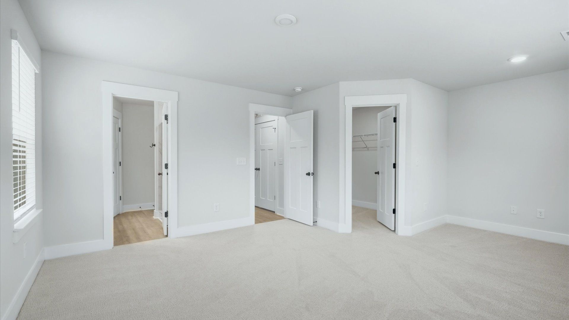 Serene and stylish primary bedroom featuring carpet flooring and a thoughtful, modern layout at Brookland Place