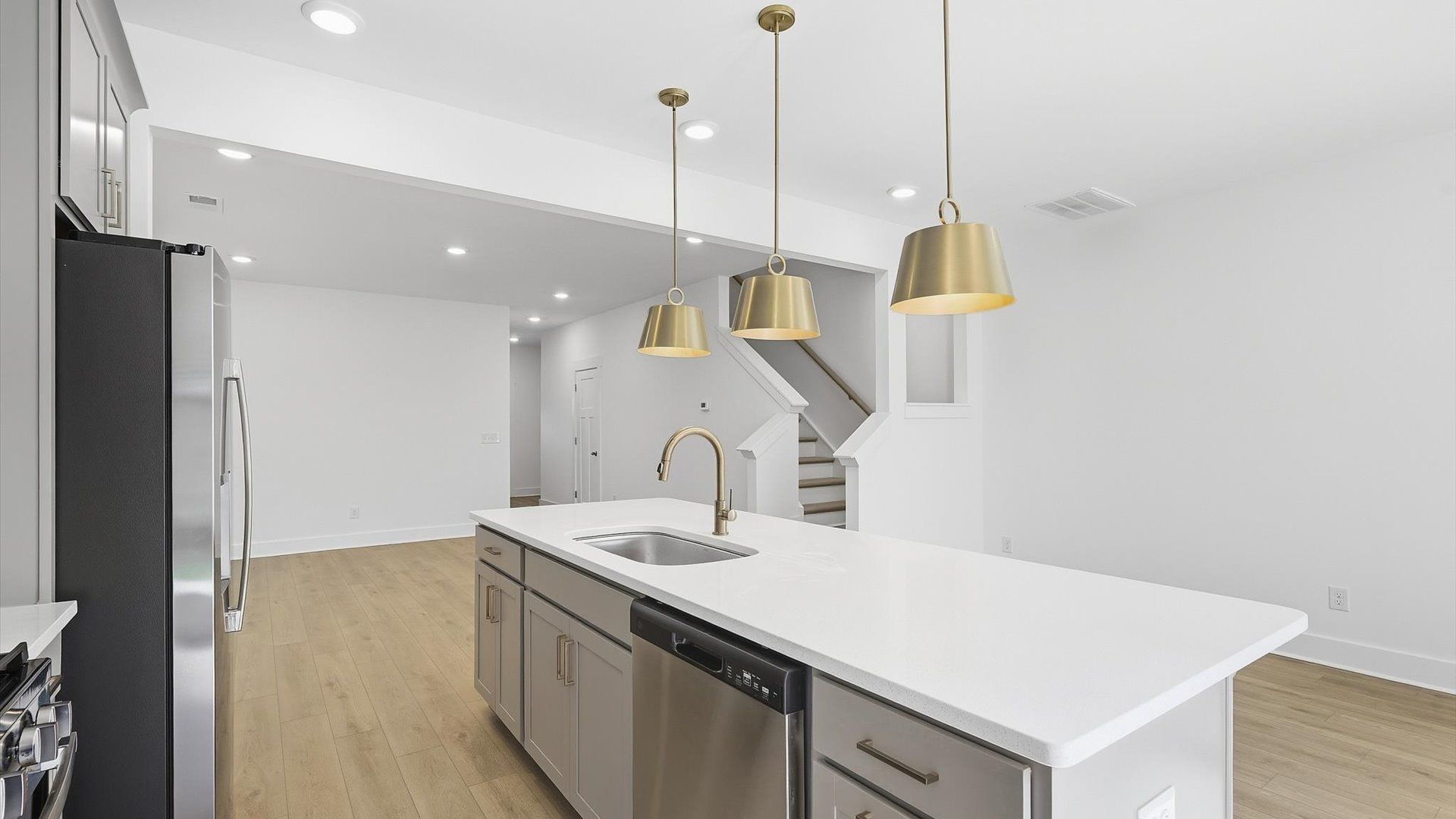 Highly skilled kitchen design includes a 9-foot island, quartz countertops, and stylish pendant fixtures