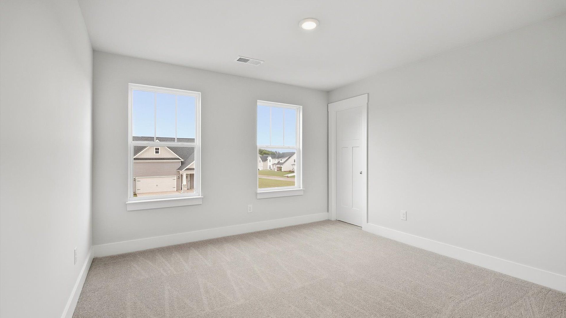 Refined bedroom design with large windows for daylight-filled mornings and peaceful views by DRB Homes