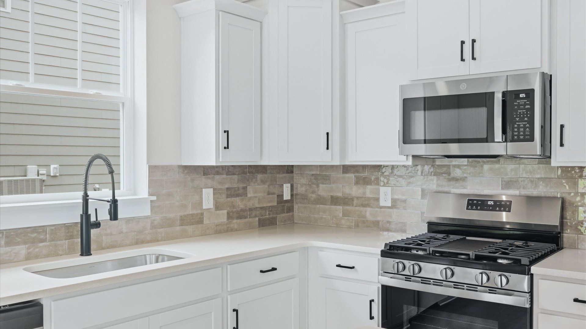 Superior kitchen with quartz countertops, white cabinets, and stainless steel appliances at Creeks at Midway