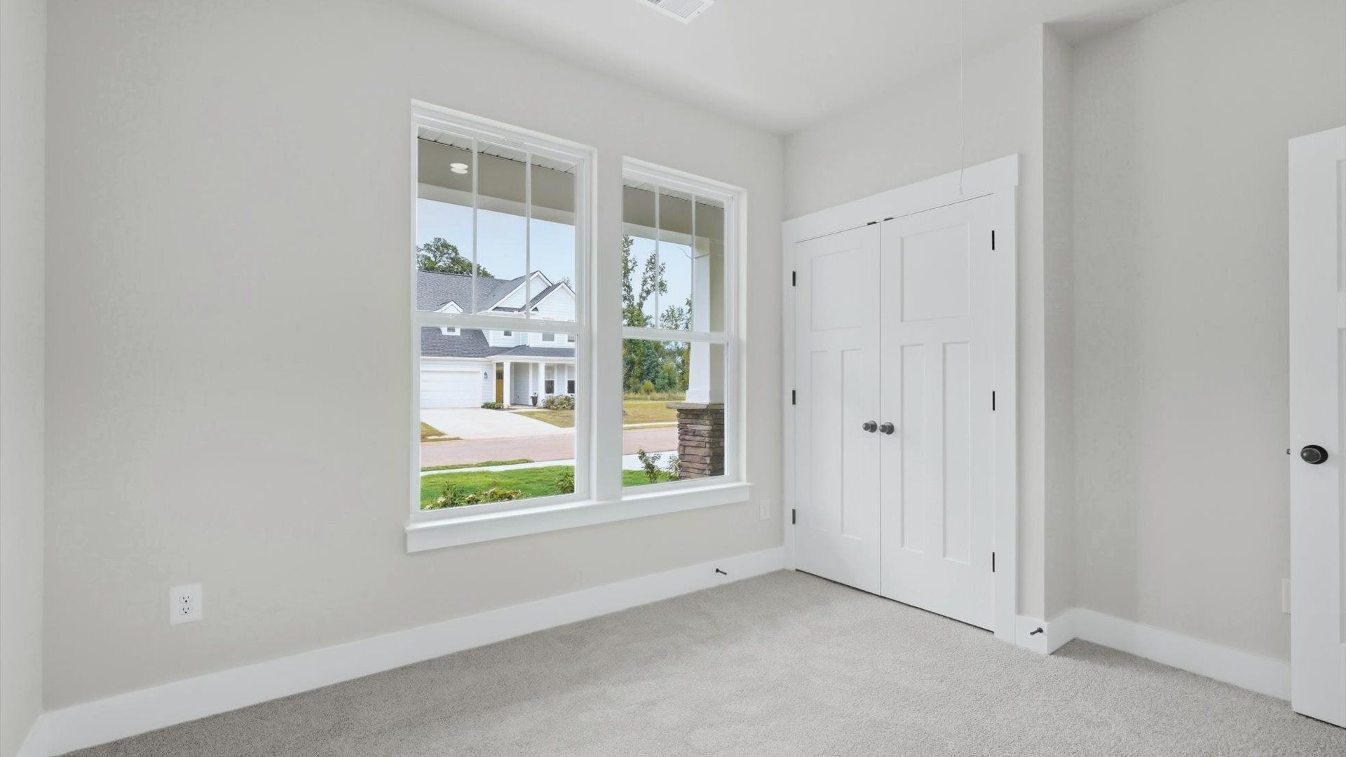 Refined bedroom design with large windows for daylight-filled mornings and peaceful views by DRB Homes