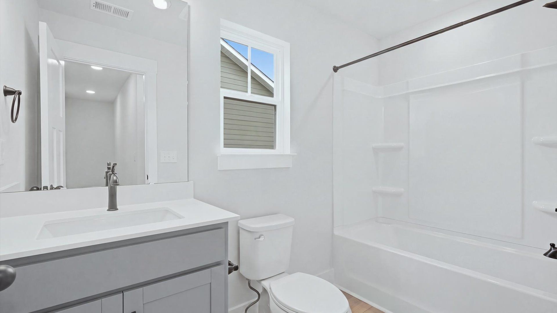 First-rate full bath featuring modern surfaces and a fresh, current color palette by DRB Homes
