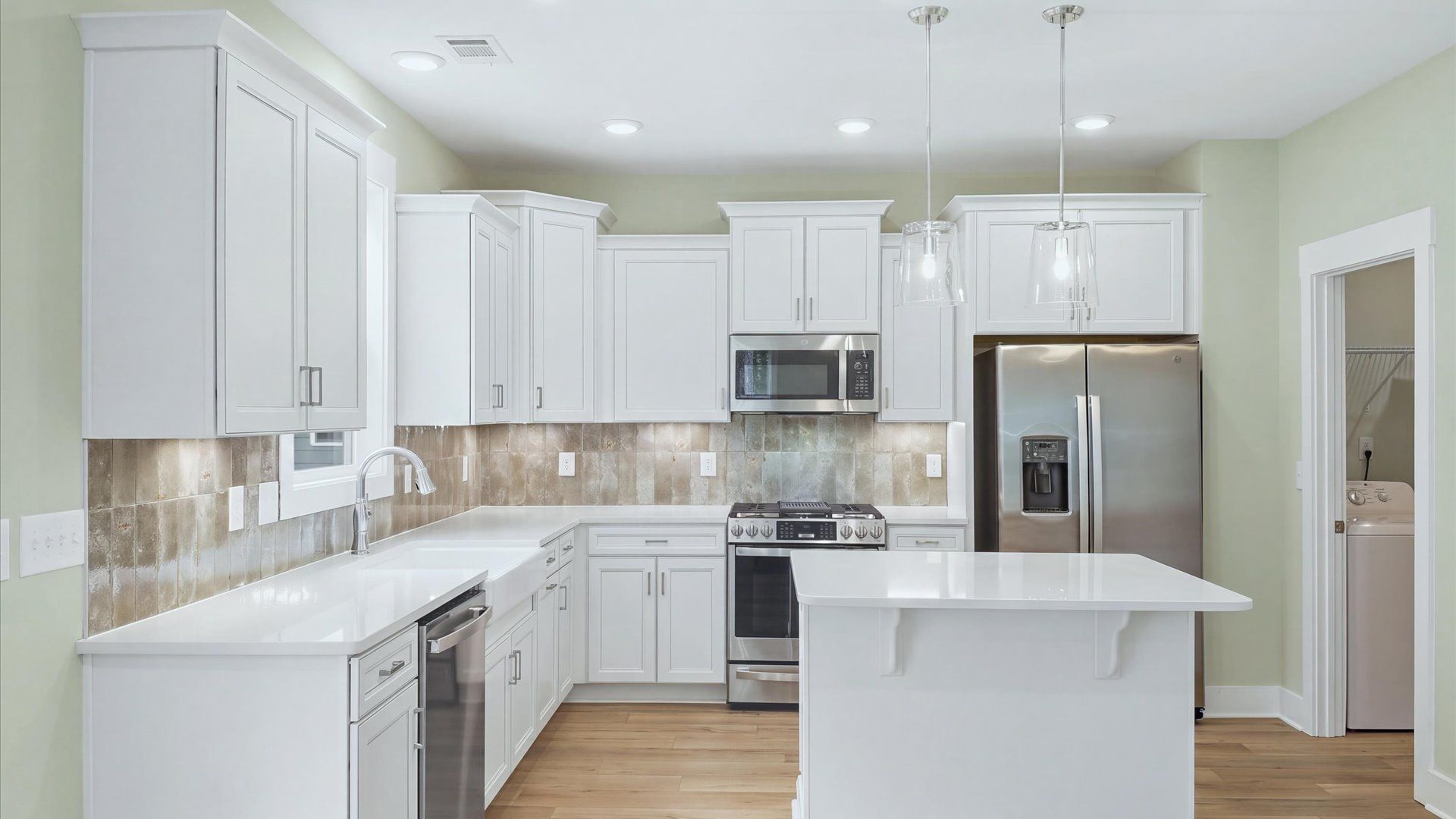 Exceptional kitchen featuring a center island, eye-catching pendant lights, and modern finishes at Creeks at Midway
